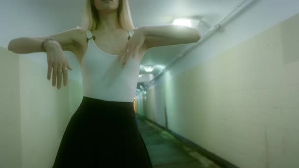 Blondýny žena v černé sukni a bílé tričko pózuje v podzemní chodbě. — Stock video