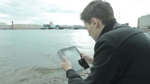 Mann benutzt Tablet-PC am See — Stockvideo