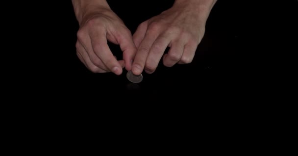 Tenant pièce de monnaie et spin sur le fond noir 