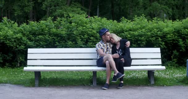 Курильщик беспокоит влюбленных на скамейке в парке . — стоковое видео