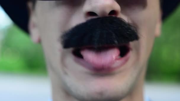 Um homem de chapéu e bigode grimaces — Vídeo de Stock