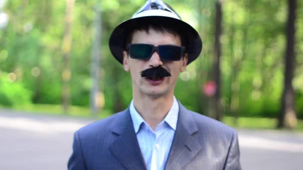 En man i en hatt och mustasch grimaser — Stockvideo