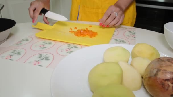 Mujer corta zanahorias en la tabla de cortar — Vídeos de Stock