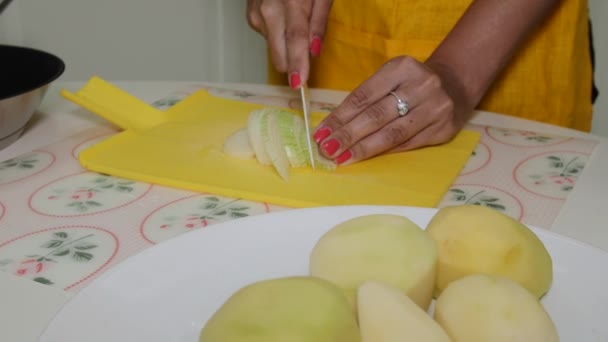 La donna taglia le cipolle su un tagliere e le versa nella padella — Video Stock