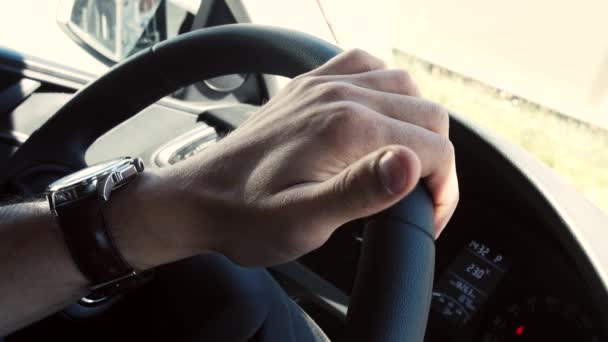 Gros plan d'une main masculine au volant dans une voiture moderne — Video