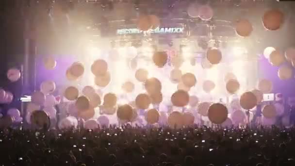 MOSCOW, RUSSIA - AUGUST 15, 2015: 20 years of Radio Record. Many balloons falls on people in the concert hall — Stock Video