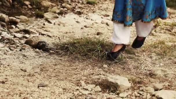 Mujer en traje nacional caucásico va a lo largo de la corriente — Vídeos de Stock