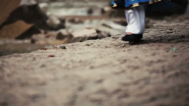 Frau im kaukasischen Nationalanzug geht Bach entlang — Stockvideo