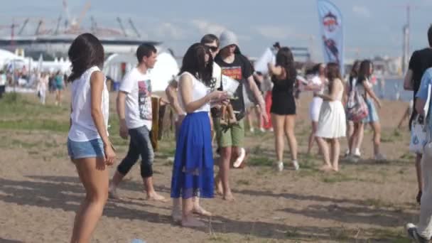 Санкт-ПЕТЕРСБУРГ, РОССИЯ - 18 июля 2015 года: VK FEST. Потрясающе красивая девушка в подрезанных шортах танцует на летней пляжной вечеринке — стоковое видео