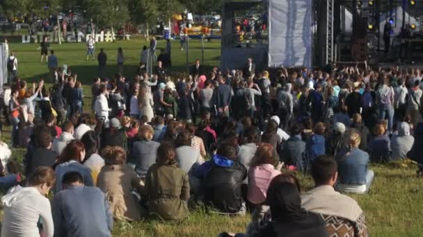 St. Petersburg, Rusya - 18 Temmuz 2015: Vk Fest. Kalabalık konser izlerken çimenlerin üzerinde oturan insan — Stok video
