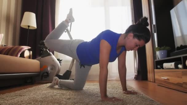 Mujer haciendo ejercicio en casa haciendo levantamientos de piernas . — Vídeo de stock