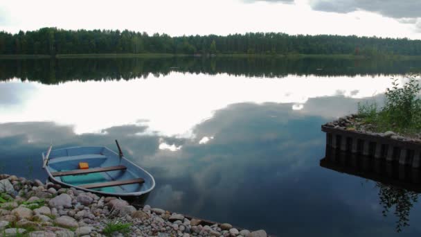 Muelle de piedra, lago con bote. Bosque verde, nublado — Vídeo de stock