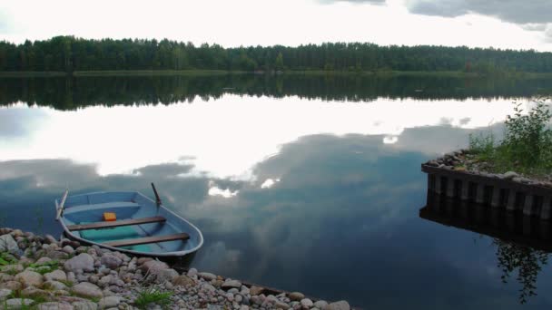 Masse en pierre, lac avec bateau. Forêt verte, nuageuse 