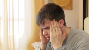 Evde bir baş ağrısı olan adam. Atış statik