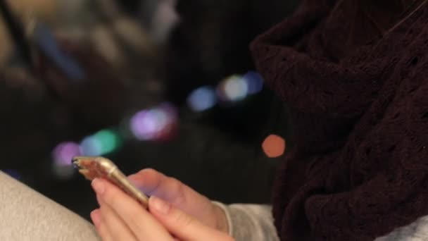 Девушка сидит на подоконнике и использует смартфон — стоковое видео