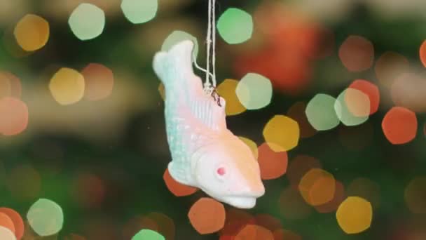 Christmas fish toy shakes at background bokeh — Stock Video