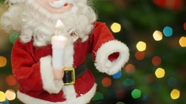 Spielzeug-Weihnachtsmann bewegt sich im Hintergrund Bokeh-Lichter — Stockvideo