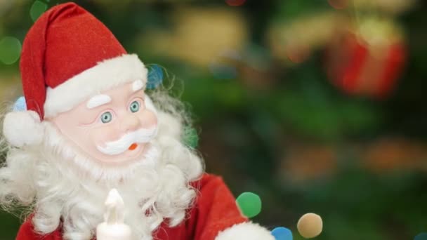 Speelgoed Santa Claus beweegt op de achtergrond bokeh lichten — Stockvideo