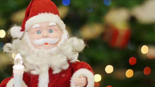 Speelgoed Santa Claus groeten op de achtergrond bokeh — Stockvideo