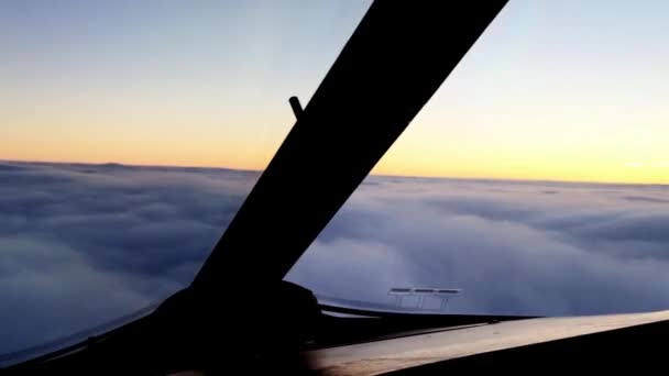 El avión se mueve por encima del cielo nublado al atardecer. Cámara en cabina de piloto . — Vídeos de Stock