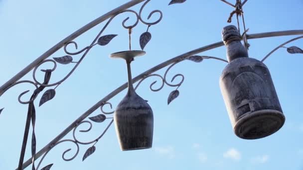 Houten wijnglas en fles blijft hangen op een touw en wiggle op een wind in zomerdag — Stockvideo