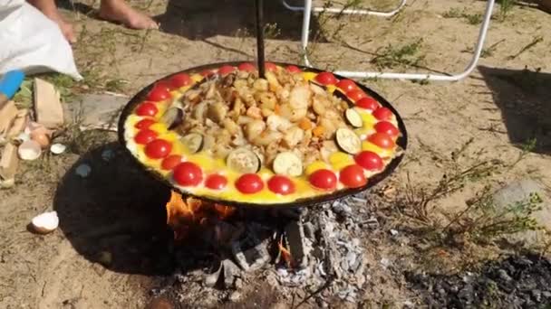 Blázen velké jídlo z brambor a zeleniny na oheň během slunečného letního dne — Stock video