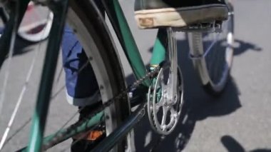 Yaz günü, pedallar ve bacaklar odakta Bisiklete binme çocuk arka tarafında. Ağır çekim.