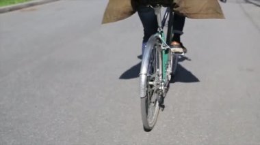 Yaz gün, Yeşil Bisiklet odakta Bisiklete binme oğlan tarafına geri. Ağır çekim.