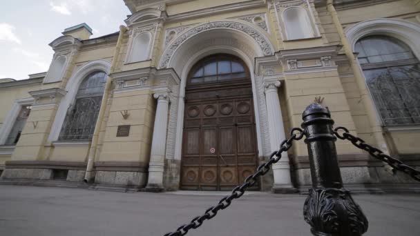 Facade af historisk bygning med stor dør på gaden i sommeraften . – Stock-video