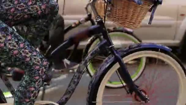 Duas meninas de bicicleta em uma rua no dia de verão, pernas e foco de bicicleta em . — Vídeo de Stock