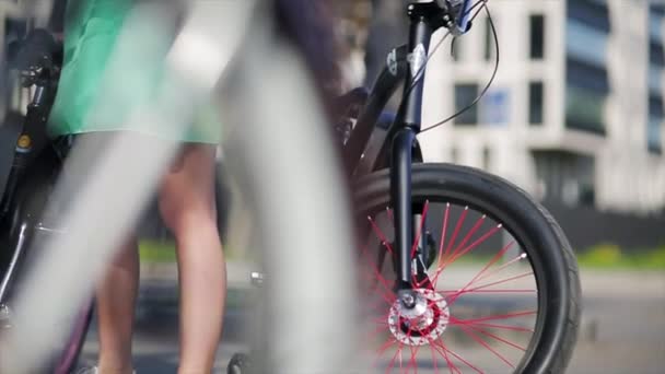 Τροχοί της τρία ποδήλατα εστίαση σε, κορίτσι κινείται ένα από ένα ποδήλατο στη θερινή ημέρα — Αρχείο Βίντεο