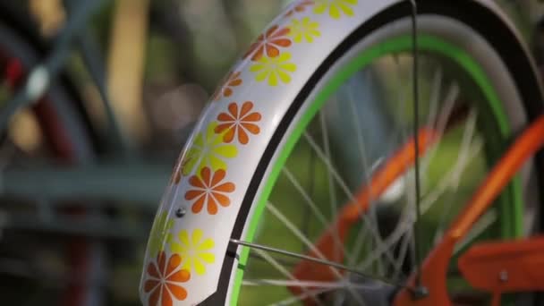 Roda giratória de uma bicicleta colorida no dia de sanny de verão. Pan vertical — Vídeo de Stock