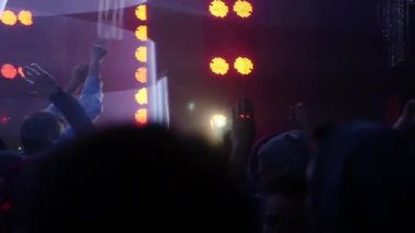 İnsanlar atlamak ve kalabalık gece kulübünde el kaldırsın. Ağır çekim.