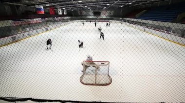 Hokey kalecisi buz pateni pisti üzerinde bir oyun bir anda arka tarafında. Ağır çekim.