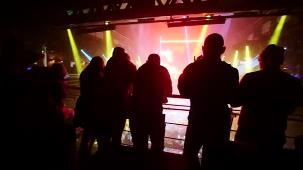 Groupe de personnes rester au deuxième étage d'une boîte de nuit et regarder vers le bas sur une foule . — Video