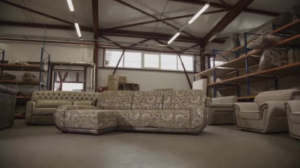 Mujer en uniforme de trabajo ven a un sofá y participar en la fábrica de muebles — Vídeos de Stock