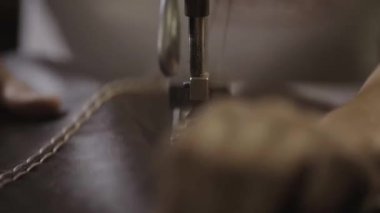 Çalışan Dikiş dikiş makinesi fabrikası tarafından deri malzeme üzerinde yapar. Yakın çekim