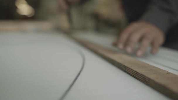 L'homme dessine des lignes sur le paralon avec rectitude par marqueur dans l'usine de meubles — Video