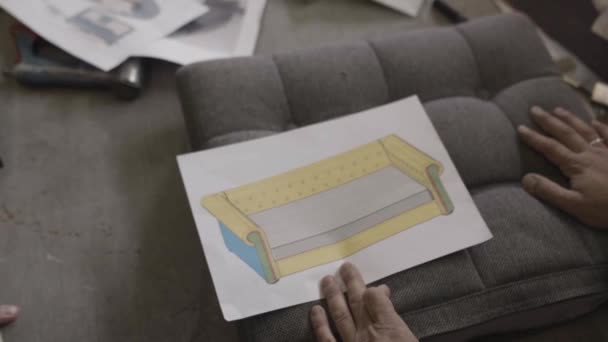 Dva muži podívat na kreslení pohovku a diskutovat v továrna na nábytek — Stock video