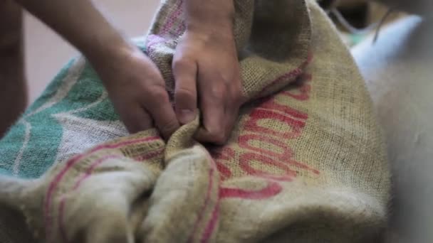 Trabajador manos desembalaje bolsa con granos de café no fritos . — Vídeos de Stock
