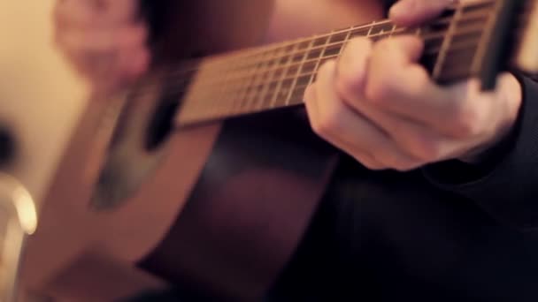 Manos de hombre tocando la guitarra acústica por mediador. Enfoque del diapasón hacia fuera . — Vídeos de Stock