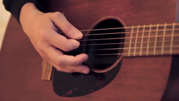 Mans mão toca em cordas de guitarra acústica por mediador. Fechar . — Vídeo de Stock