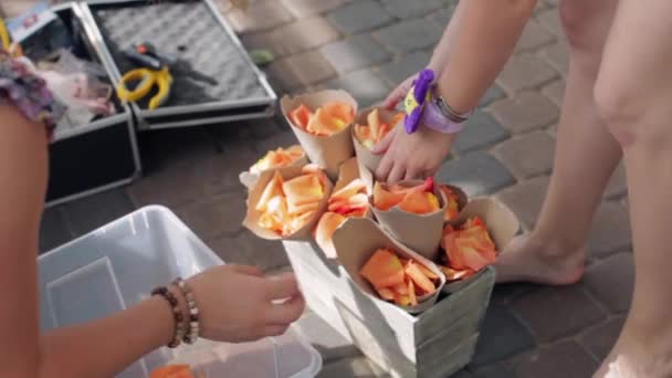 As mãos de mulher decoram o canteiro de flores de madeira por túbulos com pétalas cor-de-laranja. Verão — Vídeo de Stock