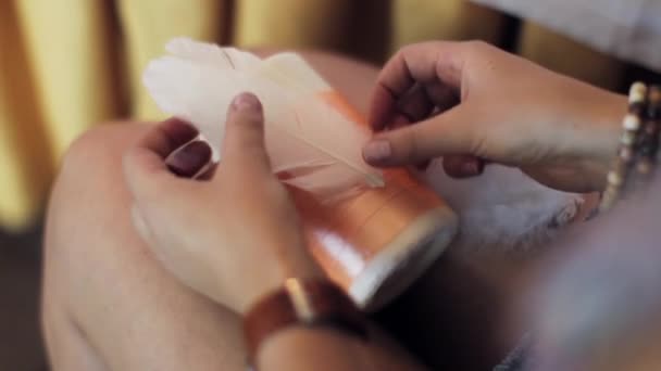 Mujeres manos pegamento bolígrafos blancos en vela grande con cinta naranja en las rodillas . — Vídeos de Stock