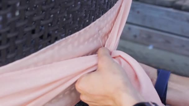 Las manos de las mujeres decoran el respaldo de la silla de textil rosa claro con alambre en verano . — Vídeos de Stock