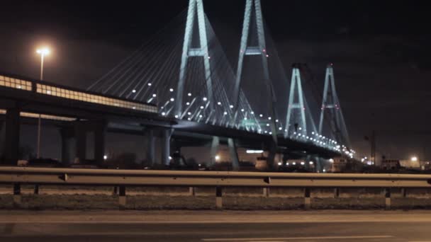 Vista del enorme puente de la autopista en la ciudad nocturna enfoque hacia fuera. Luces de iluminación . — Vídeos de Stock