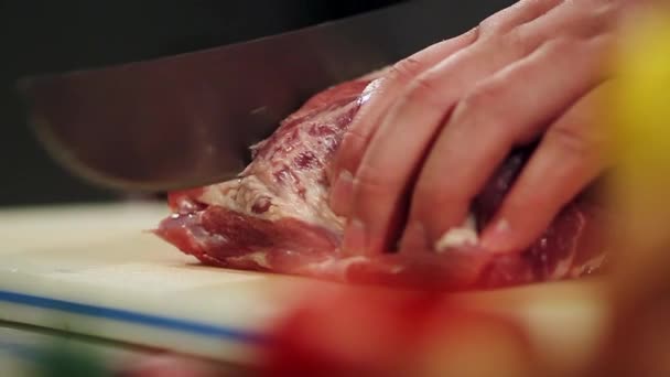 Man wirft mit der Hand frisches Fleisch und schneidet es mit einem großen Messer. Schieberegler. Zeitlupe. Nahaufnahme — Stockvideo