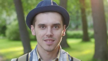 Şapka lı çocuk portresi gülümseyin ve hava öpücüğü gönderin. Yaz parkı