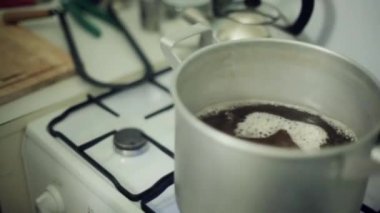 Adam el ahşap sopa tencere gaz sobası üzerinde kaynar içine atar. Sanat Evi