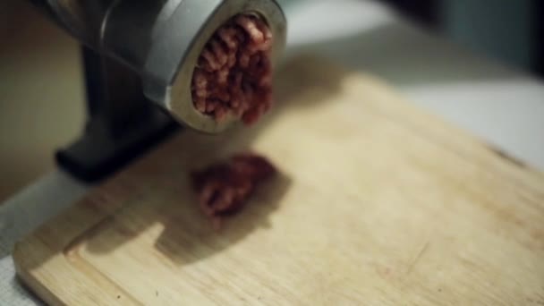 Processo di macinazione di carne fresca su tavola da cucina in legno con tritacarne in alluminio . — Video Stock